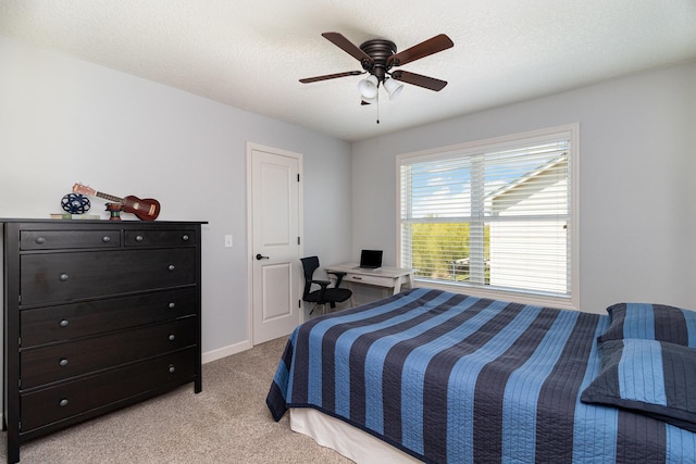 bedroom featuring light colored carpet and a ceiling fan