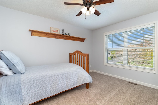 bedroom with baseboards, carpet floors, a ceiling fan, and a textured ceiling
