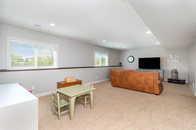 living area with a textured ceiling, light carpet, recessed lighting, and baseboards