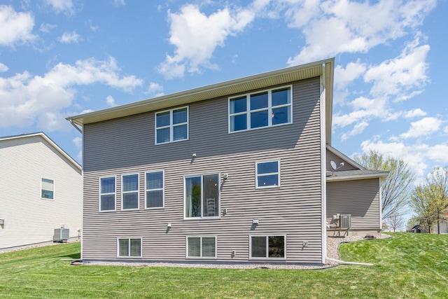 rear view of property featuring central air condition unit and a yard