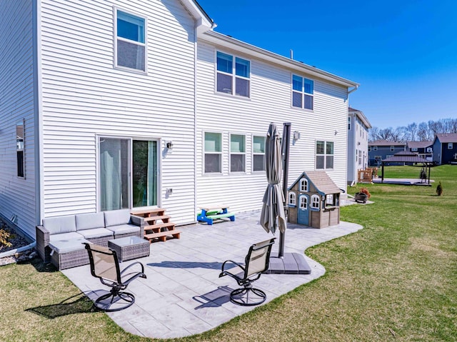 back of house with a lawn, outdoor lounge area, a patio area, and entry steps