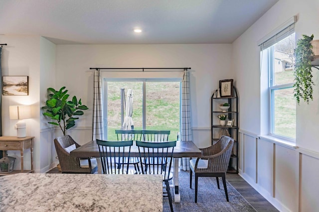 dining room with dark wood-style flooring, recessed lighting, and wainscoting