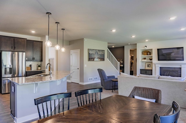 dining room with baseboards, recessed lighting, dark wood-style flooring, and built in features