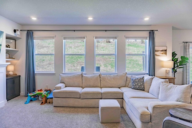 living room with recessed lighting, a textured ceiling, carpet, and a wealth of natural light