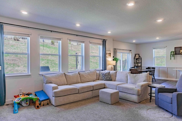 living area featuring carpet, recessed lighting, and a textured ceiling