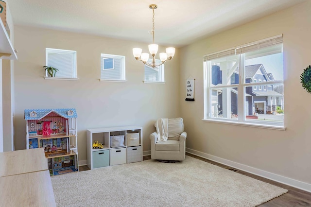 playroom with baseboards and a notable chandelier