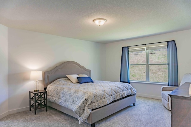 bedroom with baseboards, carpet, and a textured ceiling