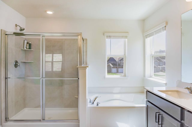 full bathroom featuring vanity, a bath, and a shower stall
