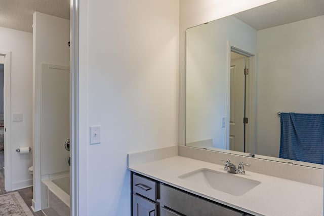 full bathroom featuring a textured ceiling, wood finished floors, and vanity