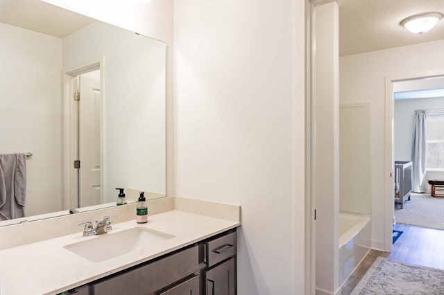 bathroom with vanity, a bathing tub, and wood finished floors