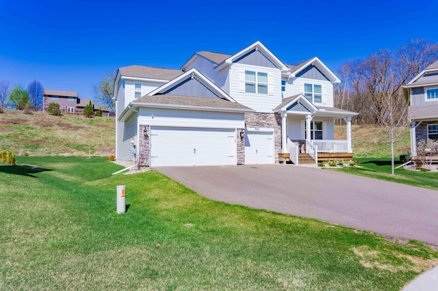 craftsman-style house featuring a front lawn, aphalt driveway, covered porch, stone siding, and board and batten siding