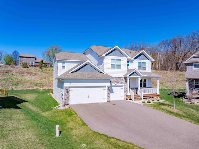 craftsman-style house featuring a porch, board and batten siding, driveway, a front yard, and stone siding