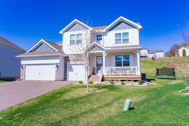 craftsman inspired home with a porch, board and batten siding, driveway, and a front yard