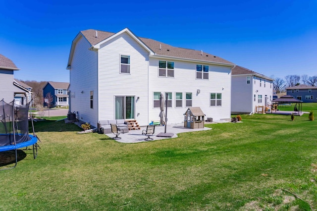 back of property with a lawn, a gazebo, a patio area, and a trampoline