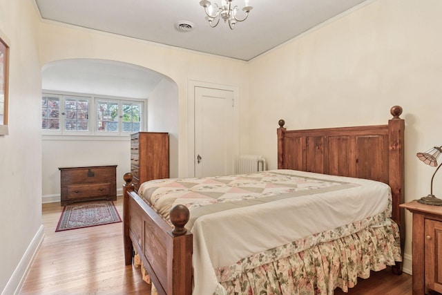 26 Mississippi River Blvd N, Saint Paul, MN 55104 - bedroom featuring radiator heating unit, arched walkways, light wood-style floors, a chandelier, and baseboards