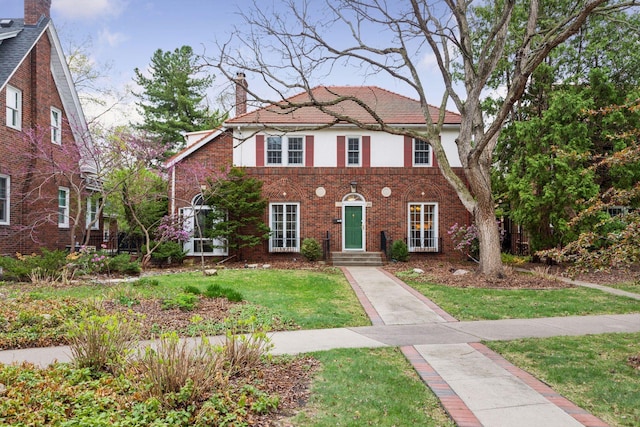 26 Mississippi River Blvd N, Saint Paul, MN 55104 - view of front of home featuring a chimney, a front lawn, brick siding, and stucco siding