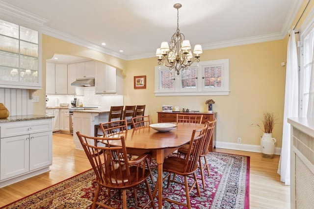 26 Mississippi River Blvd N, Saint Paul, MN 55104 - dining area with light wood-style flooring, a chandelier, ornamental molding, baseboards, and arched walkways