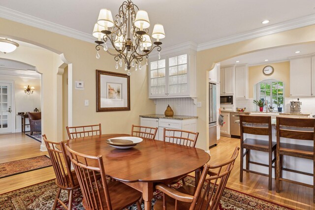 26 Mississippi River Blvd N, Saint Paul, MN 55104 - dining room with arched walkways, light wood-style floors, crown molding, recessed lighting, and a chandelier