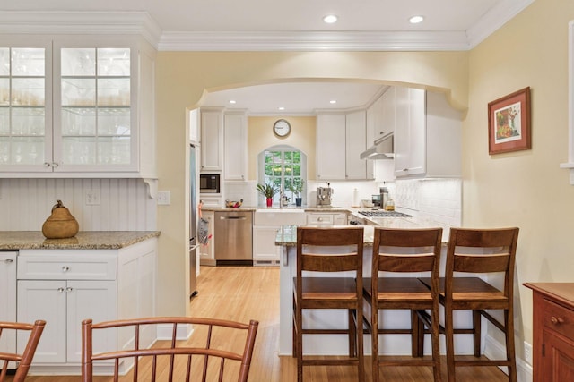 26 Mississippi River Blvd N, Saint Paul, MN 55104 - kitchen featuring stainless steel appliances, arched walkways, white cabinets, ornamental molding, and recessed lighting