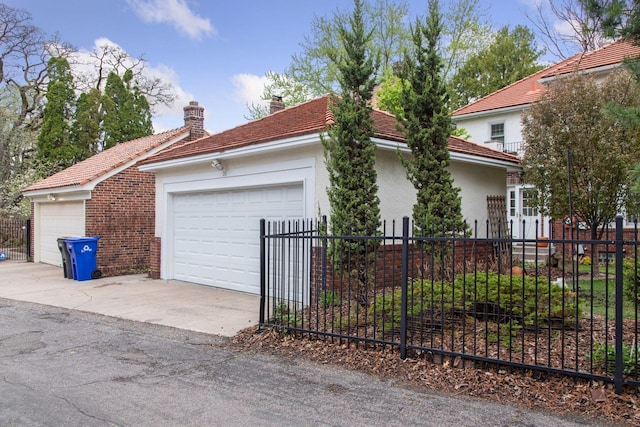 26 Mississippi River Blvd N, Saint Paul, MN 55104 - view of front facade featuring a chimney, fence, stucco siding, and a garage