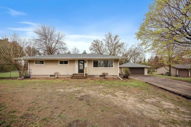 view of front facade with a detached garage, fence, an outdoor structure, and a front lawn
