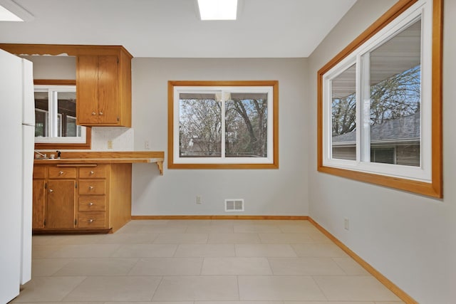 1034 Birch St, Lino Lakes, MN 55014 - kitchen with baseboards, a wealth of natural light, brown cabinetry, and visible vents