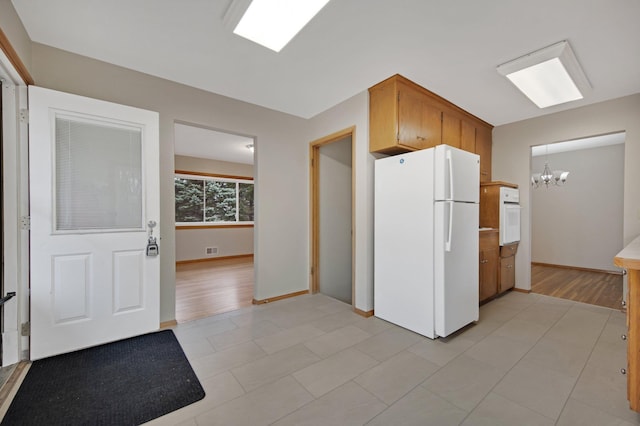1034 Birch St, Lino Lakes, MN 55014 - kitchen with an inviting chandelier, baseboards, white appliances, and visible vents
