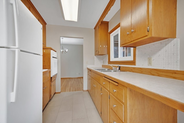 1034 Birch St, Lino Lakes, MN 55014 - kitchen featuring backsplash, a sink, light countertops, a notable chandelier, and white appliances