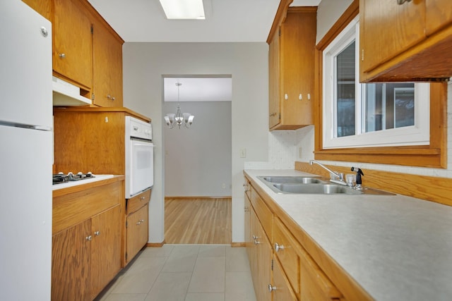 1034 Birch St, Lino Lakes, MN 55014 - kitchen with a sink, light countertops, a notable chandelier, under cabinet range hood, and white appliances