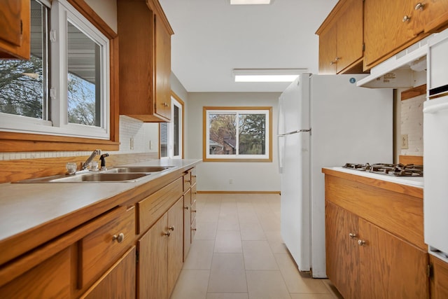 1034 Birch St, Lino Lakes, MN 55014 - kitchen featuring baseboards, white gas cooktop, light countertops, under cabinet range hood, and a sink