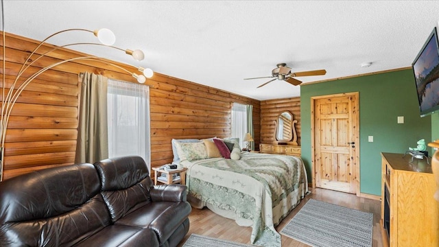 18100 Stockhousen Rd NW, Evansville, MN 56326 - bedroom with a textured ceiling, log walls, a ceiling fan, and wood finished floors