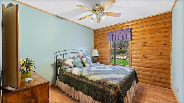 18100 Stockhousen Rd NW, Evansville, MN 56326 - bedroom featuring a ceiling fan, crown molding, wood walls, baseboards, and light wood-style floors