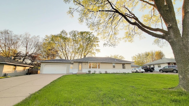 single story home with a front lawn, an attached garage, and concrete driveway