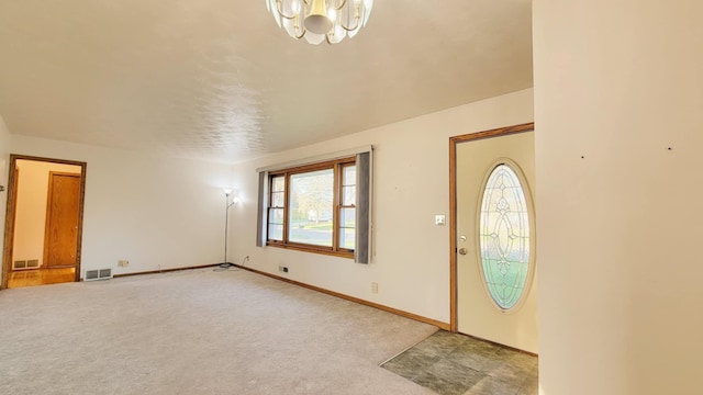 entryway featuring a chandelier, light colored carpet, and baseboards