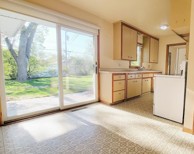 kitchen with range, light countertops, plenty of natural light, and baseboards