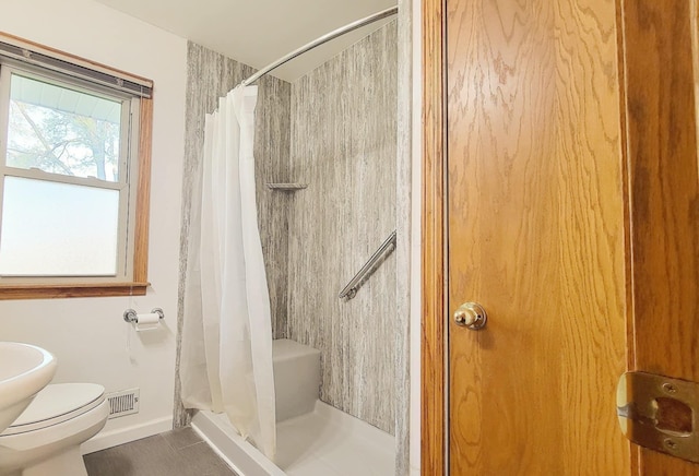 full bath with a stall shower, toilet, baseboards, and tile patterned flooring