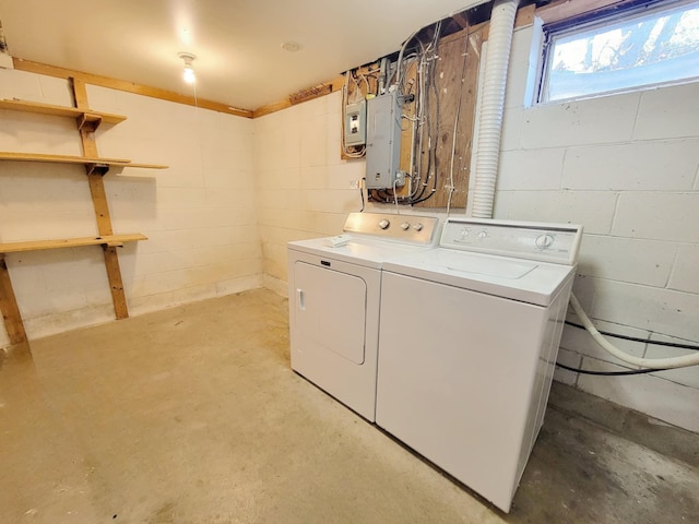 laundry room featuring independent washer and dryer, electric panel, and concrete block wall