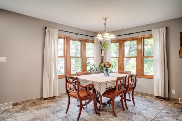 5371 Hugo Rd, White Bear Twp, MN 55110 - dining room with healthy amount of natural light, a chandelier, and light stone finish floors