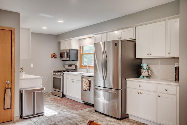 5371 Hugo Rd, White Bear Twp, MN 55110 - kitchen featuring stainless steel appliances, a sink, decorative backsplash, white cabinets, and light countertops