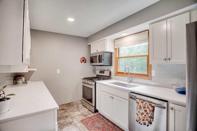5371 Hugo Rd, White Bear Twp, MN 55110 - kitchen with stainless steel appliances, a sink, decorative backsplash, light countertops, and white cabinetry