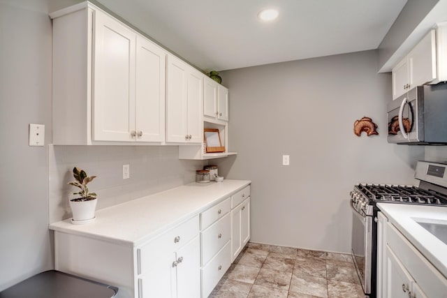 5371 Hugo Rd, White Bear Twp, MN 55110 - kitchen with stainless steel appliances, white cabinets, decorative backsplash, light countertops, and baseboards