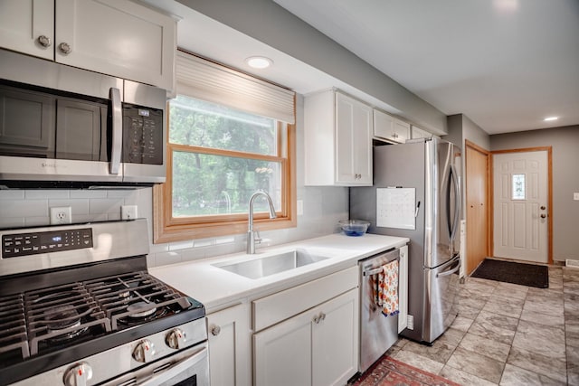 5371 Hugo Rd, White Bear Twp, MN 55110 - kitchen with appliances with stainless steel finishes, a sink, white cabinetry, tasteful backsplash, and light countertops