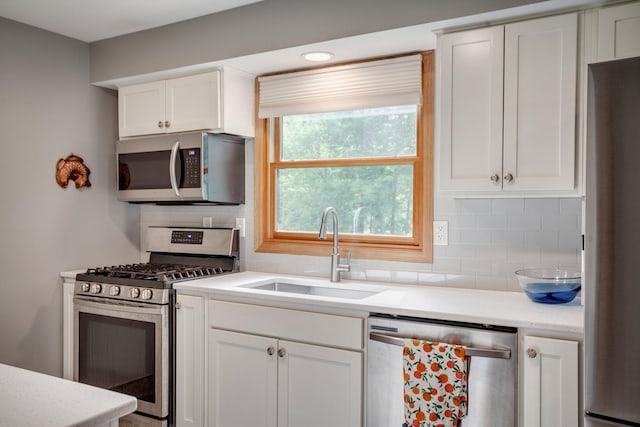 5371 Hugo Rd, White Bear Twp, MN 55110 - kitchen featuring stainless steel appliances, a sink, light countertops, tasteful backsplash, and white cabinets