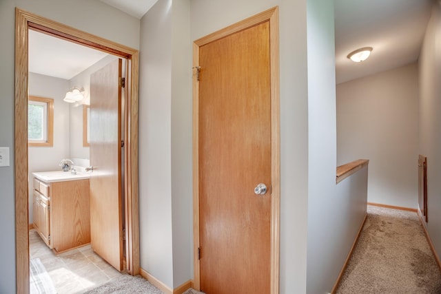 5371 Hugo Rd, White Bear Twp, MN 55110 - hallway featuring an upstairs landing, light carpet, baseboards, and a sink