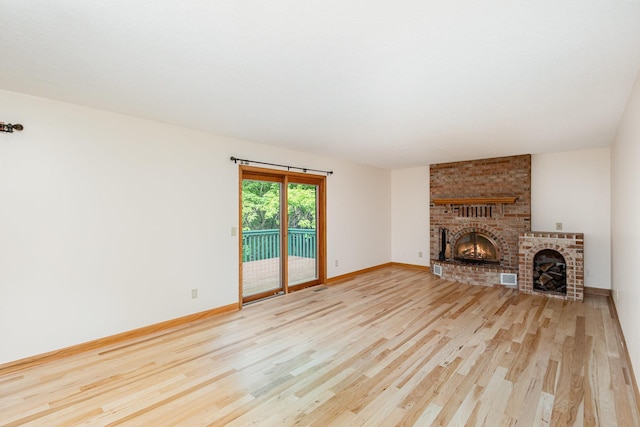 8762 Highwood Way, Apple Valley, MN 55124 - unfurnished living room with a brick fireplace, wood finished floors, and baseboards