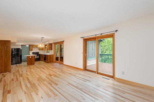 8762 Highwood Way, Apple Valley, MN 55124 - unfurnished living room with light wood-style floors, healthy amount of natural light, baseboards, and a sink