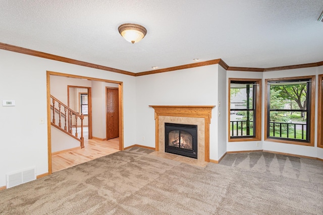 8762 Highwood Way, Apple Valley, MN 55124 - unfurnished living room featuring carpet, baseboards, a tile fireplace, stairway, and crown molding