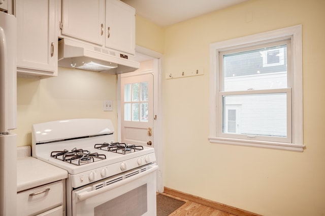 4830 29th Ave S, Minneapolis, MN 55417 - kitchen featuring white appliances, under cabinet range hood, light wood-style flooring, white cabinets, and light countertops