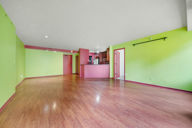 401 1st St Unit 401, Minneapolis, MN 55401 - unfurnished living room featuring light wood-style floors, a textured ceiling, and baseboards