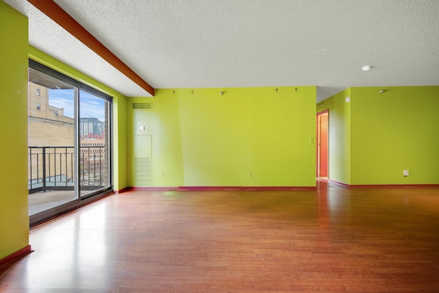 401 1st St Unit 401, Minneapolis, MN 55401 - unfurnished room featuring wood finished floors, a textured ceiling, and baseboards